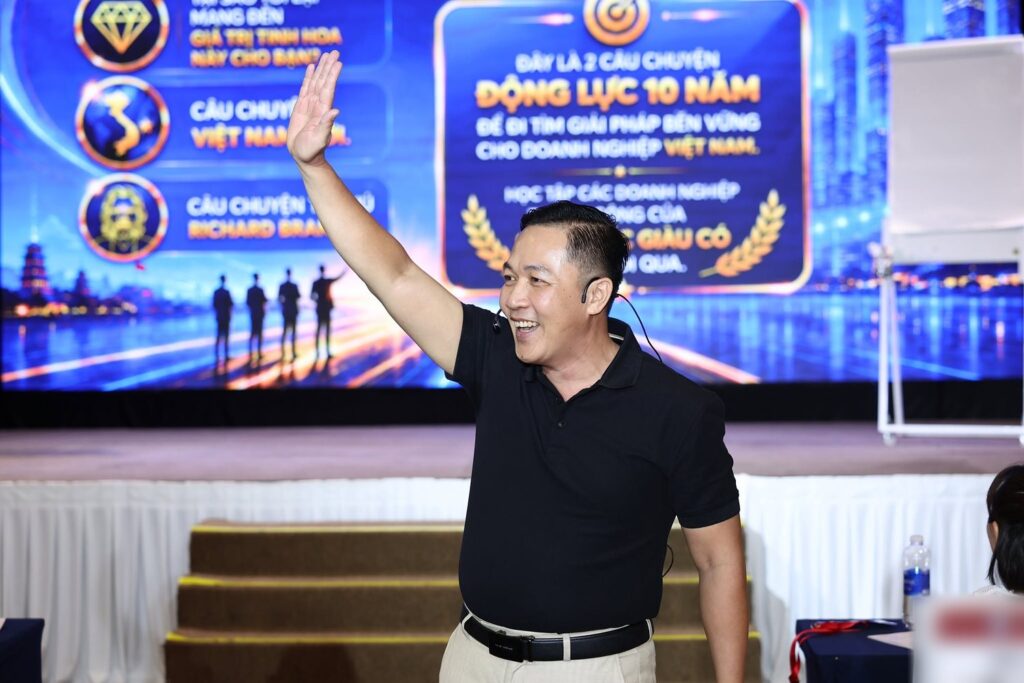 Thầy Dương Minh Triết giơ tay chào học viên trên sân khấu chương trình Động lực 10 năm